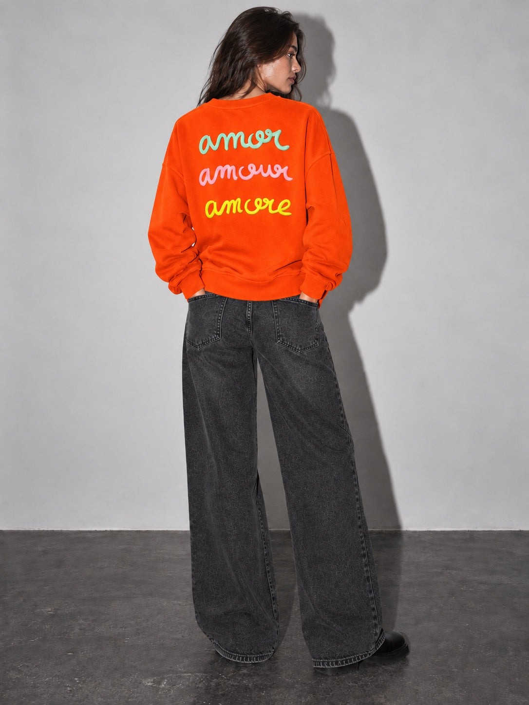 Sudadera Amore naranja de mujer con letras en relieve, modelo espalda